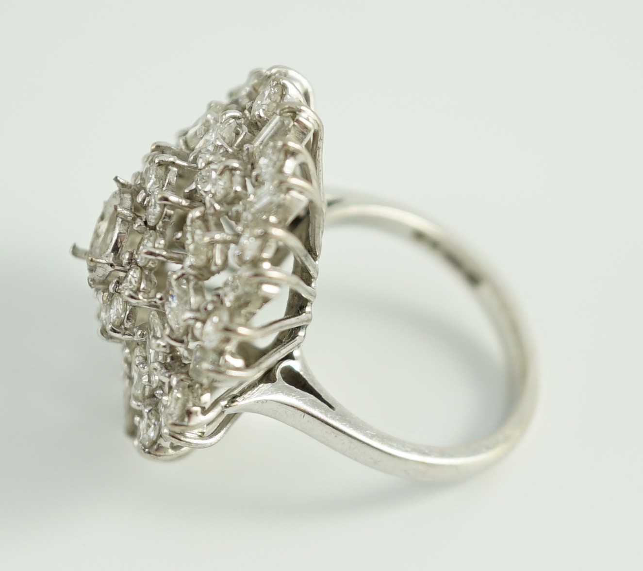 A modern 18ct white gold, ruby and round, baguette and marquise cut diamond cluster set dress ring